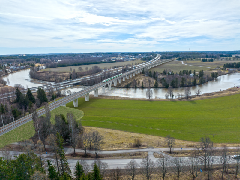 Hankkeen havainnekuva, jossa silta ylittää joen ja ruohoaluetta.